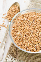 raw spelt on wooden background