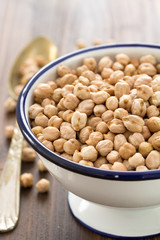 chick-pea in white bowl on brown wooden background