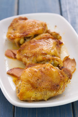 fried chicken with smoked meat on white plate on wooden background