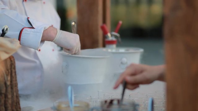 Human put chocolate on nitrogen iceacream.