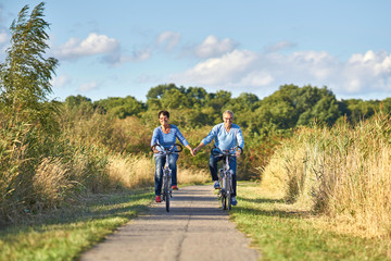 Radfahren in der Natur, lachendes Seniorenpaar mit Fahrr&auml;dern