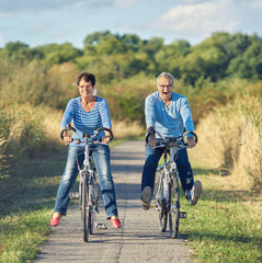 lachende Senioren bei einer Radtour, Freude im Rentenalter