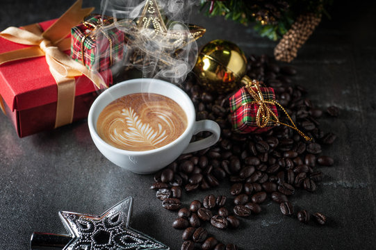 Coffee cup and christmas toys with pine brench on black stone background .