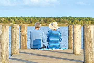 Senioren sitzen am See, entspannter Ausflug