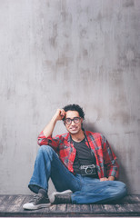 Getting the best photos. Handsome young Afro-American hipster holding camera and smiling while sitting against grey background