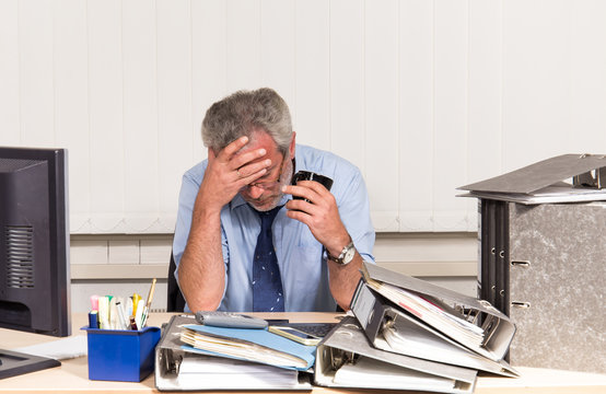 Mann mit Burnout Stress am Schreibtisch