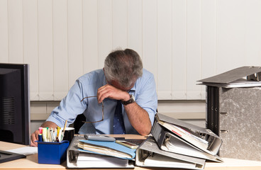 Mann mit Burnout Stress am Schreibtisch