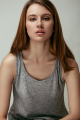 Beauty portrait of beautiful young model with long red hair in tank top. Proud girl.