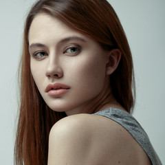 Closeup beauty portrait of a young fashion model with red hair and natural makeup . Pretty face.