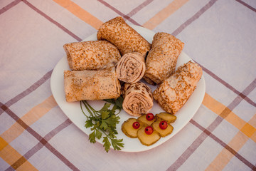 Tasty pancakes with meat on white plate closeup. Crepes stuffed with finely cut meat.