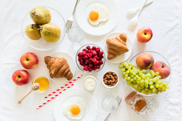 Summer healthy breakfast on white table cloth. Top view