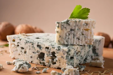 Fototapeten Slice of French Roquefort cheese  with walnuts, copy space. © elnavegante