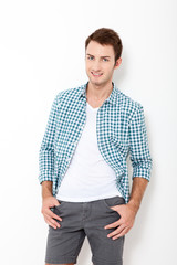 Young man standing against white background. Happy young man. Portrait of handsome Man in casual shirt and smiling while standing against at white wall