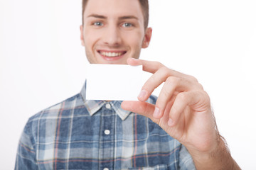 Young man holding white blank billboard close-up on white background.