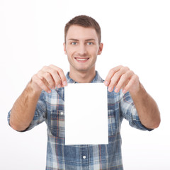 Young man holding white blank billboard close-up on white background.