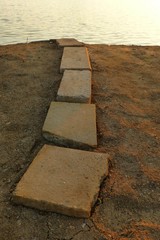 Provisorisch gepflasterter Weg am Ufer eines Badesees