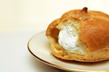 Fresh eclairs with cream on a plate, close up