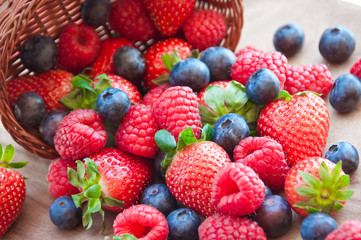 Fototapeta premium Fresh berries (raspberries, blueberries, strawberries) in basket