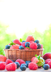 Fresh berries (raspberries, blueberries, strawberries) in basket © Maresol