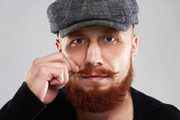 male face with mustache and beard.fashion Portrait of young bearded man in hat