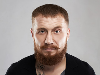 male face with mustache and beard.bearded brutal criminal with tattoo
