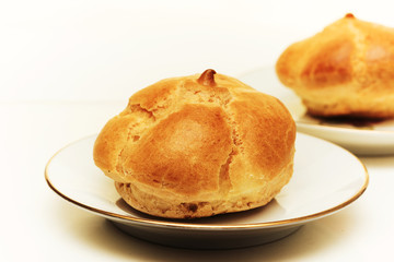 Fresh eclair with cream on a plate, close up
