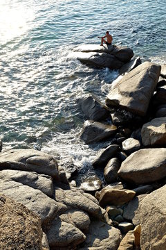 pescatore amatoriale su uno scoglio
