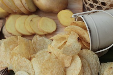 Crispy potato chips with salt and fresh potatoes.