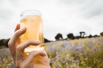 Close-up of hand holding a bottle of honey