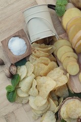 Crispy potato chips with salt and fresh potatoes.