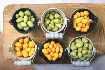 A closeup plan view of the bucket full of nuts on the wooden background

