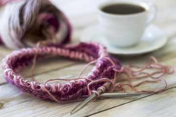 Skeins of wool and knitting needles on wooden background
