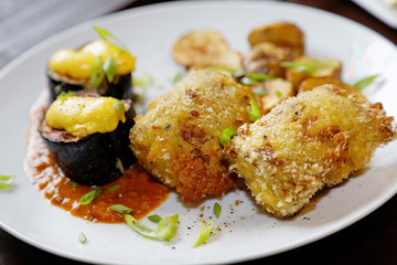 Plate with baked eggplant and potatoes on the table