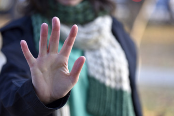 Woman put forth a hand in stopping gesture