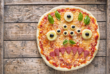 Halloween creative scary food eye monster zombie face pizza snack with mozzarella, basil and...