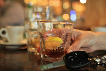 Don't drink and drive concept. Woman drinking alcohol drink and car keys. Responsibly and safety...