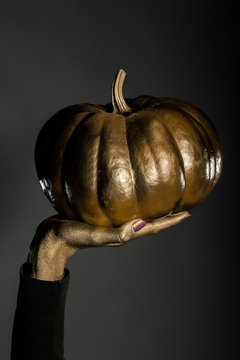 golden halloween pumpkin in female hand