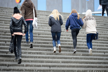 Obraz premium Young crowd walking up the stairs in the rain