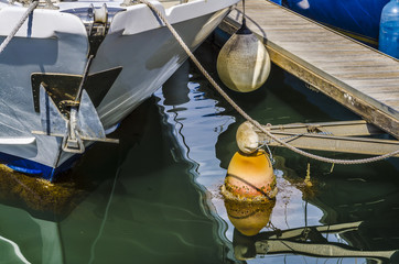 bateau amarré au ponton avec ancre et flotteur