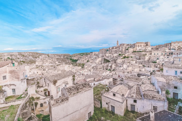 Fototapeta na wymiar typical house of stones (Sassi di Matera) and church of Matera under blue sky. Matera in Italy