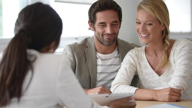 Cheerful married couple meeting financial adviser