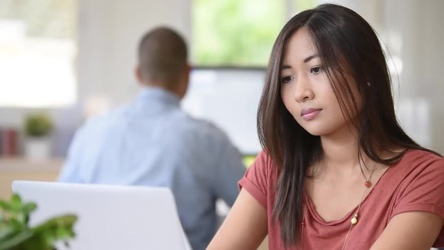Young asian mixed-race woman working in office