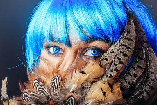Man in blue wig behing feathers
