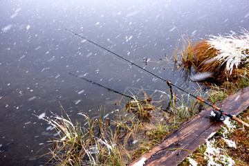 Autumn fishing under snowfall on the lake - 122771354