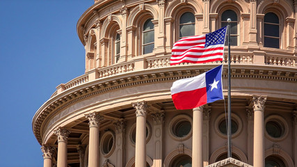 American and Texas state flags flying on the dome of the Texas State Capitol building in Austin - obrazy, fototapety, plakaty