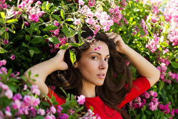 Fototapeta premium Pretty girl among blossoming flowers
