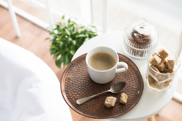 Coffee with sweets served on table in cozy loft room