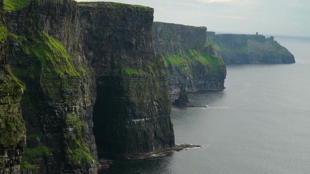 The big rocks and the sea in Moher Cliffs Ireland it is an amazing view with lots of people visiting the spot