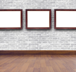 Picture frame on brick wall and wooden floor.