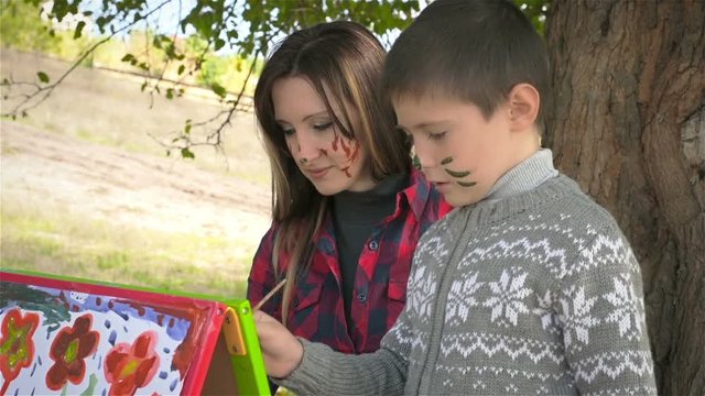 Mother with six year old son paint sunny picture